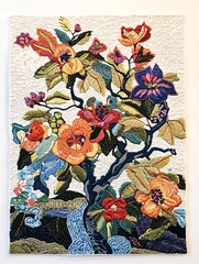 Vibrant needlepoint artistry on a pristine backdrop highlights elaborate designs and the charm of handmade stitching.