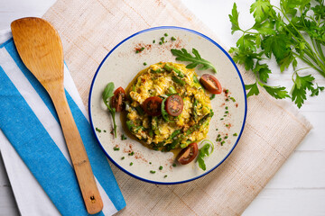 Scrambled organic chicken eggs with green asparagus and tomato. Top view table with  decoration.