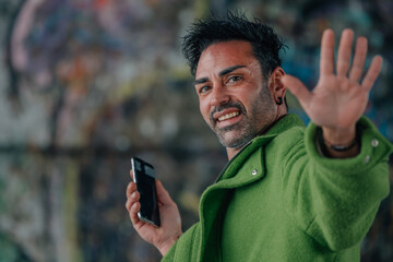 young man on the street waving