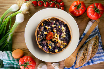 Individual vegan quiche with vegetables and red cabbage. Top view table with  decoration.