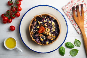 Individual vegan quiche with vegetables and red cabbage. Top view table with  decoration.