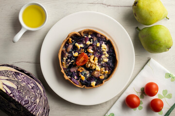 Individual vegan quiche with vegetables and red cabbage. Top view table with  decoration.
