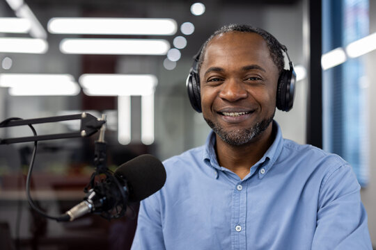 Confident radio host with headphones and microphone recording engaging podcast in studio. He exudes warmth and professionalism, creating content for audience.