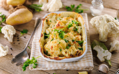 cauliflower gratin with ingredients on a wooden surface. Perfect for healthy eating and baked comfort food