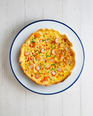 Individual quiche with vegetables and crab surimi. Top view table with decoration.