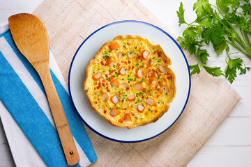 Individual quiche with vegetables and crab surimi. Top view table with decoration.