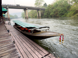 Fototapeta premium A boat is docked at a pier with a bridge in the background