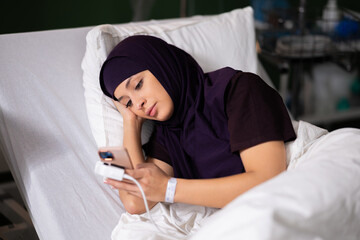 Arab woman using her phone for virtual visits, staying connected with loved ones.