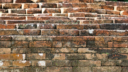 Close-up of weathered bricks from an ancient temple, showing natural aging, moss growth, and rustic textures. Ideal for history, architecture, and texture themes