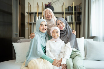 Portrait of happy multi-generation muslim family in a living room at home