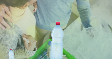 Image of ecology texts with recycling symbol over diverse couple sorting plastic bottles