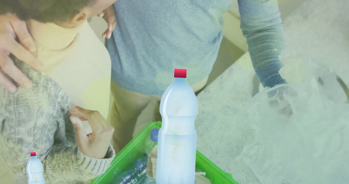 Image of ecology texts with recycling symbol over diverse couple sorting plastic bottles - Powered by Adobe