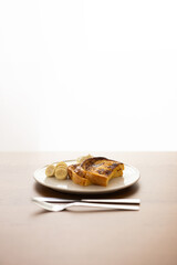 朝日の差し込む窓辺で、木製のテーブルの上に置かれたフレンチトースト