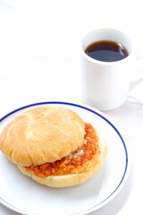 オーストリア発祥のロールパン、カイザーゼンメルに、ハムカツを挟んだサンドイッチと、淹れたてのコーヒー
