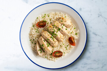 Baked chicken with thyme aroma on white rice. Top view table with decoration.