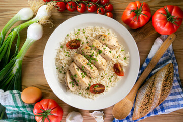 Baked chicken with thyme aroma on white rice. Top view table with decoration.