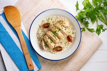 Baked chicken with thyme aroma on white rice. Top view table with decoration.