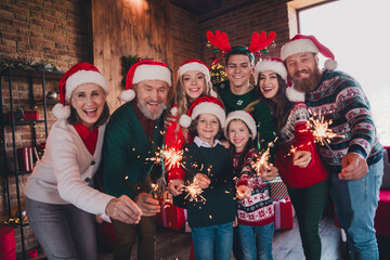 Fototapeta premium Portrait of friendly peaceful family have good mood hold sparklers gather celebrate new year xmas flat indoors