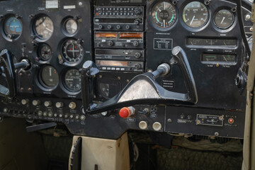 The steering wheel and control panel l cockpit of an old small airplane parked in a museum