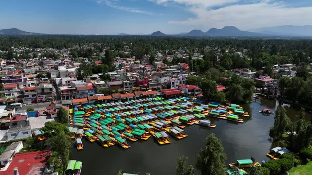 Aerial view orbiting Trajinera boats parked at the Xochimilco Lake, in sunny Mexico