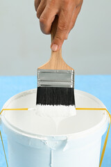 Using a rubber band across its center causes the paint will drip across the rubber band and back into the can to minimize the mess