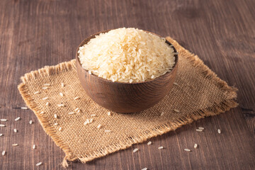 Uncooked white rice in a wooden bowl. Healthy cereal concept.  