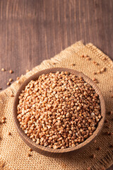 Buckwheat groats on wooden background. Healthy cereal concept