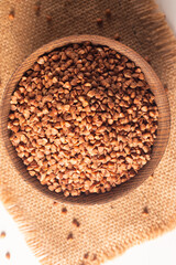 Buckwheat groats on wooden background. Healthy cereal concept