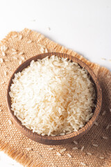 Uncooked white rice in a wooden bowl. Healthy cereal concept.  