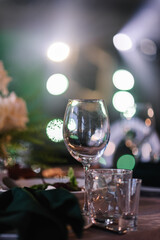 Luxury table settings for fine dining with glassware, and blurred background for event. Preparation for holiday props for wedding, birthday, and celebration. Empty glasses set in restaurant.