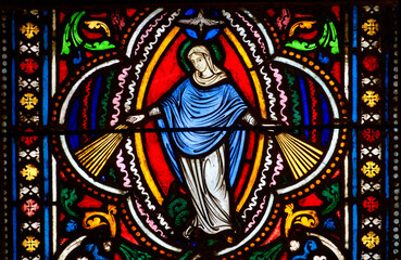 Stained glass (Nineteenth century) of The Virgin of the Miraculous Medal with rays of light symbolizing the graces that emanate from her hands.