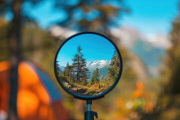 A tranquil campsite reflecting vibrant mountains and clear skies in a round mirror during a sunny day