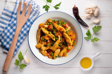 Sautéed chicken strips with vegetables and tomato sauce. Top view table with  decoration.