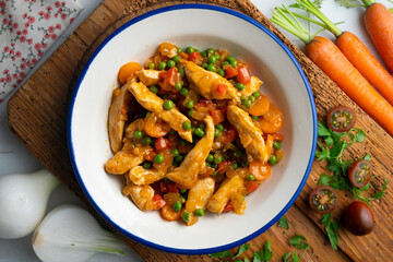 Sautéed chicken strips with vegetables and tomato sauce. Top view table with  decoration.