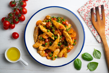 Sautéed chicken strips with vegetables and tomato sauce. Top view table with  decoration.