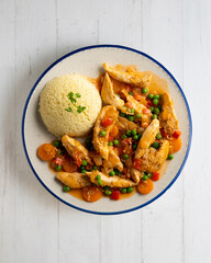 Sautéed chicken strips with vegetables and tomato sauce. Top view table with  decoration.