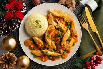 Sautéed chicken strips with vegetables and tomato sauce. Top view table with Christmas decoration.