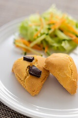 白い皿に乗せられたスコーンとサラダ