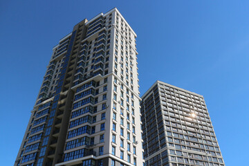 Obraz premium Modern high-rise skyscrapers against the blue sky. Multi-storey residential real estate.
