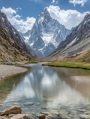 A majestic mountain peak reflected in a tranquil lake with a clear blue sky and white clouds.
