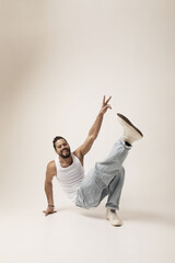 Happy young man dancing and posing in the studio. Mind set and mental health. Isolated.