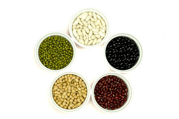 Black beans azuki beans, green beans, white beans and soybean in white cups, isolated on white background with clipping path top view flat lay. Diet and healthy food concept.