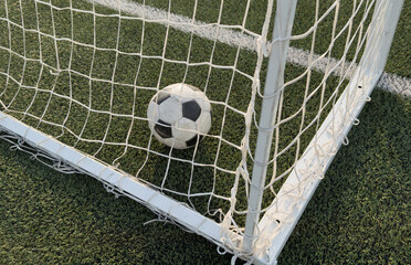 Soccer ball in goal on blue background