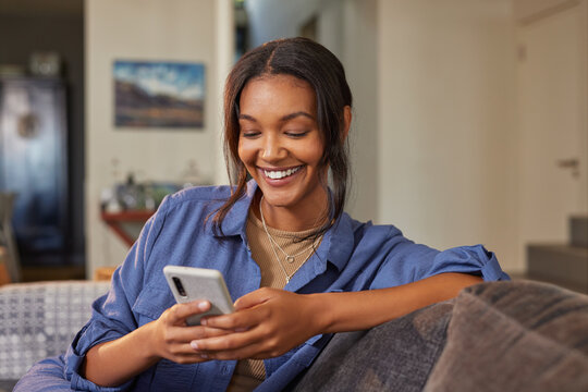 Beautiful multiethnic woman using phone at home