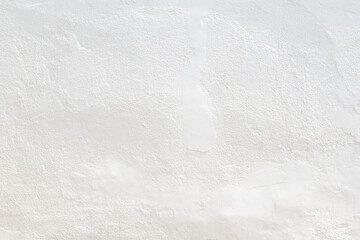 Front view of a clean and blank plastered wall painted in white on sunny day. Abstract high...