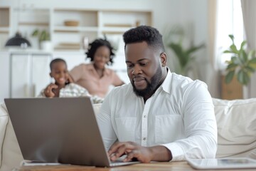 Obraz premium remote work at home, black man is sitting working at laptop, businessman, family is in the background, freelancer