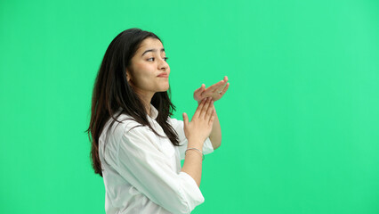 A woman, close-up, on a green background, shows a pause sign