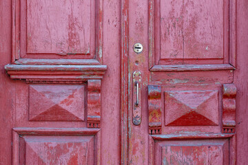 Old traditional painted wooden door with handle. Ancient closed wooden entrance door close-up. Vertical photo