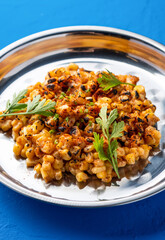 Mexican Style Grilled Corn kernel with with Chili, Lime and coriander served in plate isolated on blue background closeup side view of spicy grill vegan snack