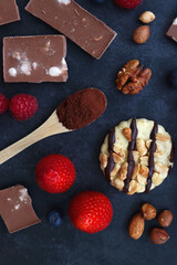 Macarons, chocolate, cookies, berries and various nuts on dark blue background. Top view.